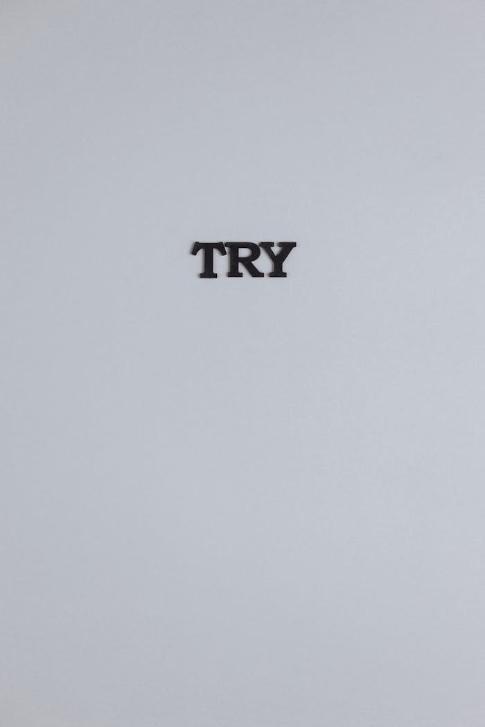 A simple minimalist display of the word 'TRY' on a smooth grey background, perfect for motivation.